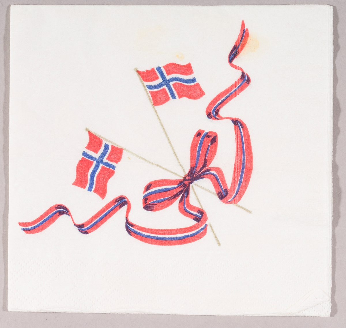 To norske flagg i kryss. Et bånd i blått, rødt og hvitt med sløyfe.