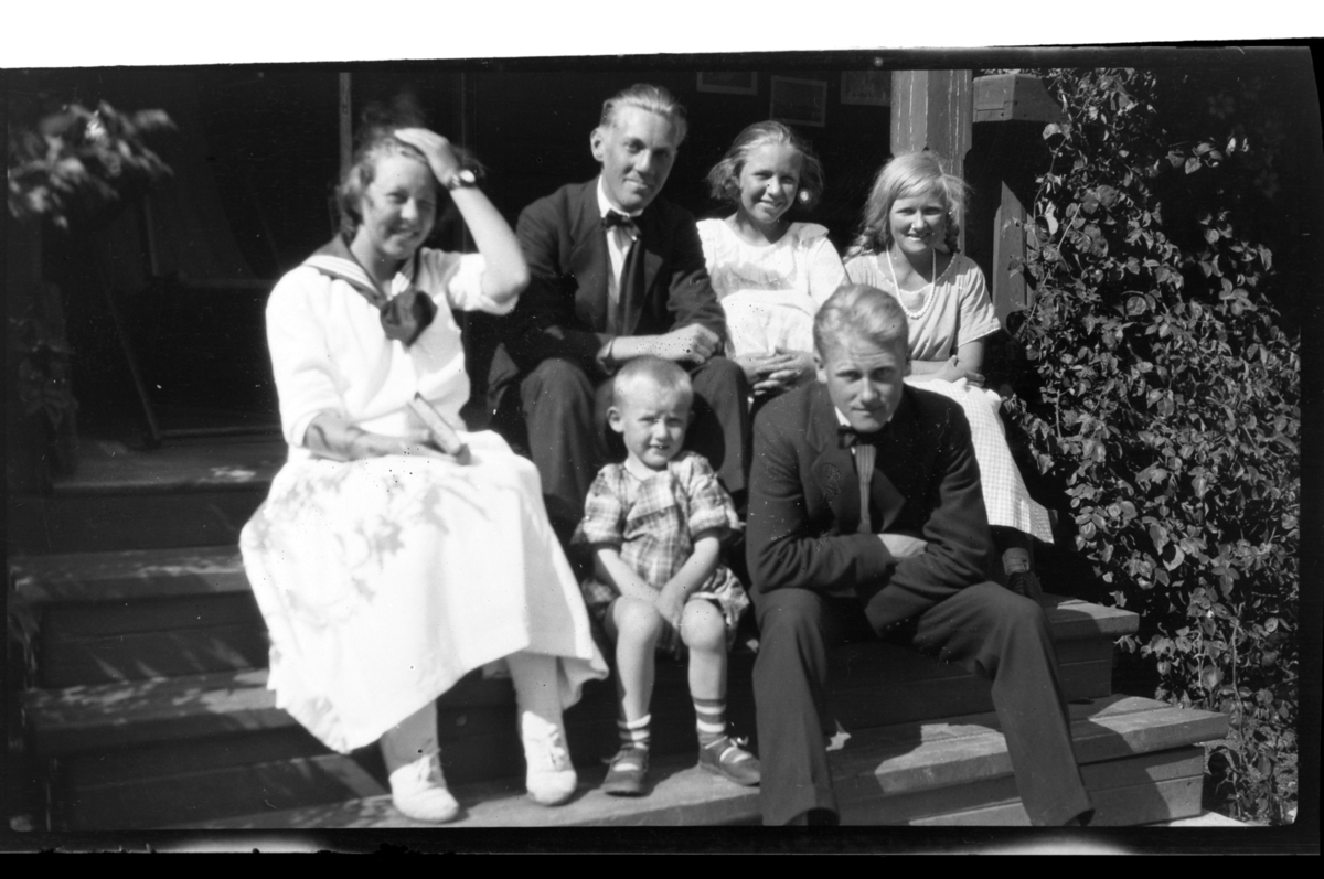 (Øverst fra venstre) Vesla Strøm, Roar Strøm, ukjent person, Cecilie (Essemor) Sundt, (foran fra venstre) Julius Sundt og Peter Sundt sitter sammen på en trapp, Stavern. Fotografert 1920.