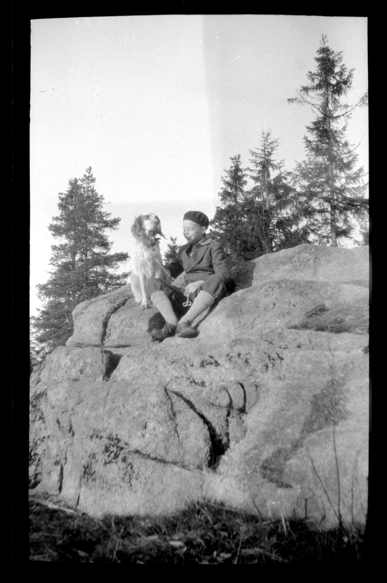 Einar Aubert Hansen sitter på en fjellknaus med en hund.