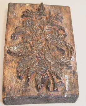 Tryckstock för mönstertryck av trä. Utskuret mönster i form av ett blomknippe.