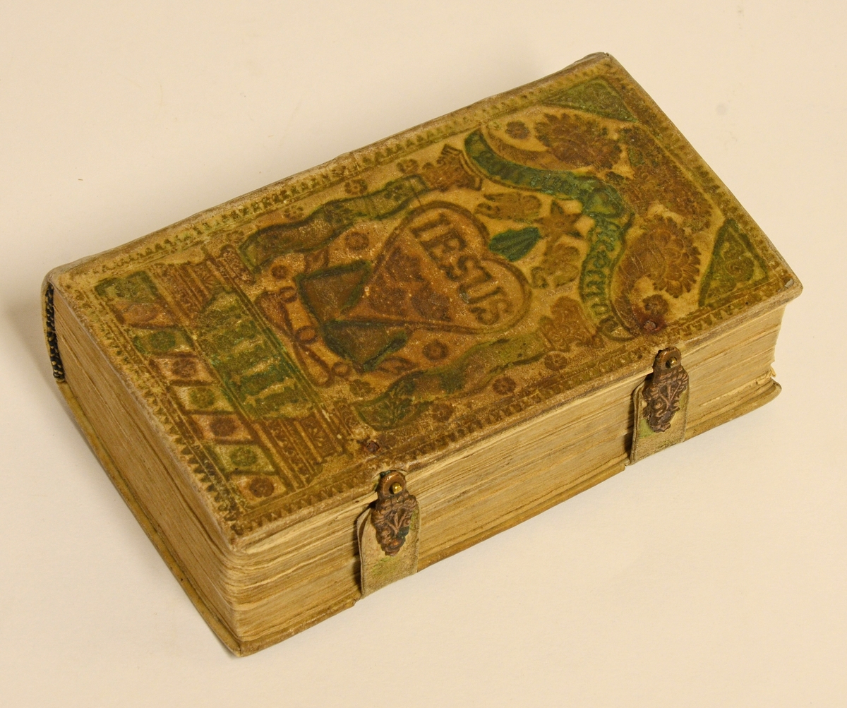 Psalmbok av pressat pergamentband, delvis målad i gult och grönt.