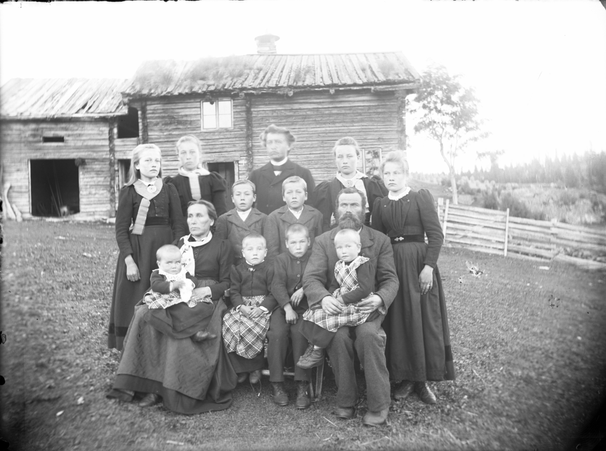 Rikard Berges fotoarkiv. Gruppebilde, Øyfjell. Fotografert 1906 i tunet på Nigard Lid i Øyfjell. Det er Gjermund og Sigrid Lid med barneflokken, Rikard Berge, i midten i bakerste rekke.
