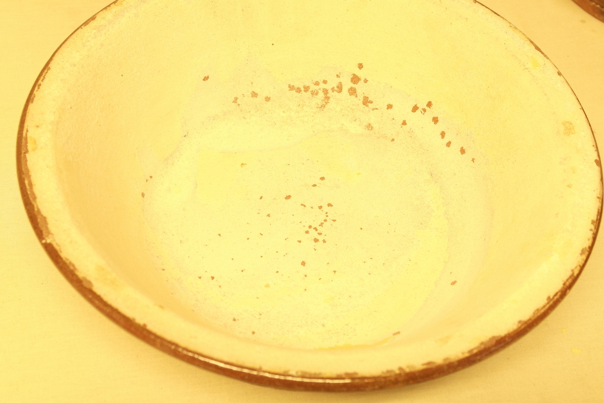 Fem fat (a-e) i keramikk. Alle har opprinnelig hatt brun glasering utvendig og gulhvit glasering inni. Fatene har ulik størrelse.