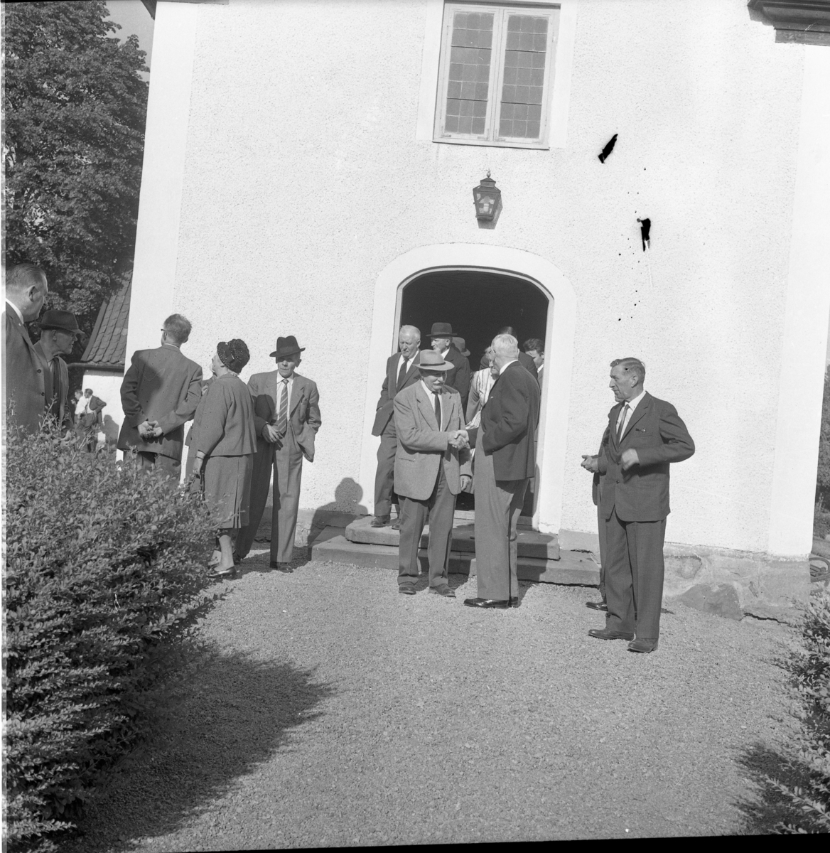 "De gamlas dag" i Gränna har utfärd till Sandseryd. Oidentiferade äldre män och kvinnor kliver ut ur kyrkan. Mannen till vänster med hatt är troligen Nils Nilsson ("Nisse på Rota")