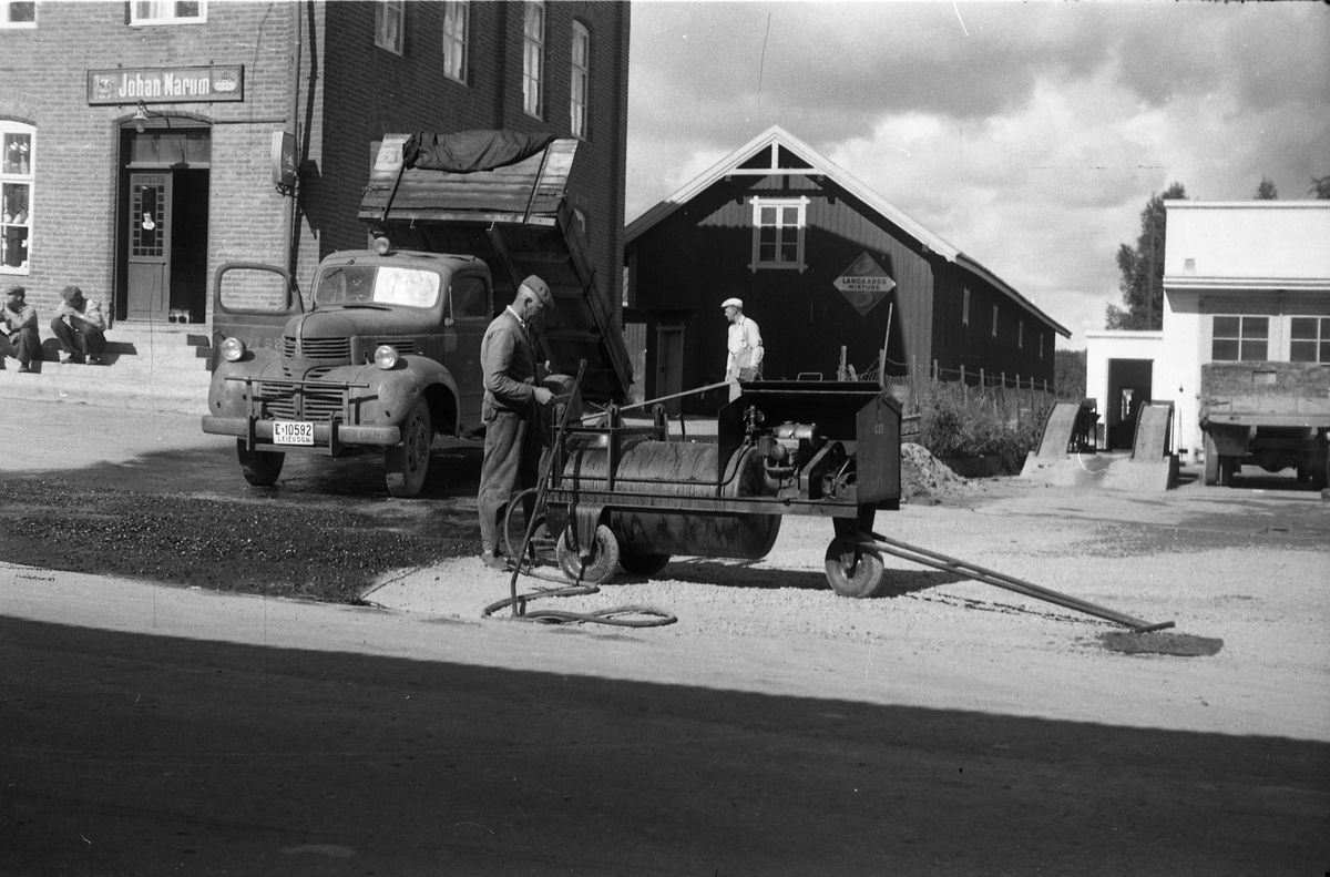 Asfaltarbeide utafor Narums-butikken på Lena, juli 1952.
Lastebilen i skal ifølge informant være en Dodge av årgang 1946-47.