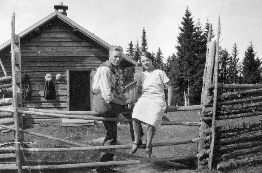 Ukjent par på le-staurene. Bildet er tatt ved størhuset på vangen til Søstua Nordre Berg på Korbølsetra i Knapper en gang i 1930-åra. Ukjent fotograf.