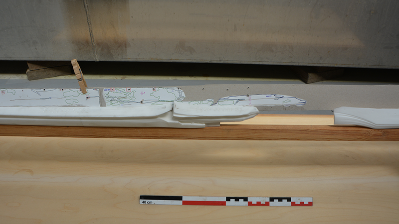 Nærbilde av 3D-printede kjøldeler i hvit plast montert på treramme. Et av kjølbordene i papp er også montert på babord side av kjølen. (Foto/Photo)
