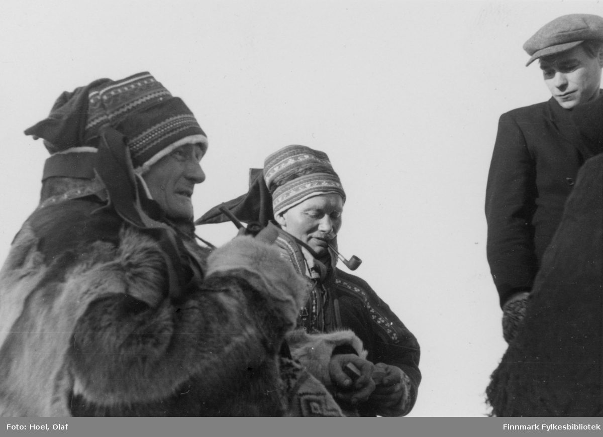 To samiske menn med pipe i munnen og en ung mann. En serie med 14 fotografier av landsgymnasets vintertur til Gargia Fjellstue rundt 1950. Til Bossekop-markedet samlet seg samene med sleder og reinsdyr ved Gargia Fjellstue.

Olaf Hoel (1903-1970) var den første rektoren ved fylkets første gymnas Finnmark off. Gymnas i Alta i årene 1948-1952. Kjell F. Hoel har gitt en liten bildesamling etter sin far fra hans tid i Alta til Finnmark fylkesbibliotek. Olaf Hoel gjorde en pionerinnsats for skolen under gjenreisningen av landsdelen etter krigen.