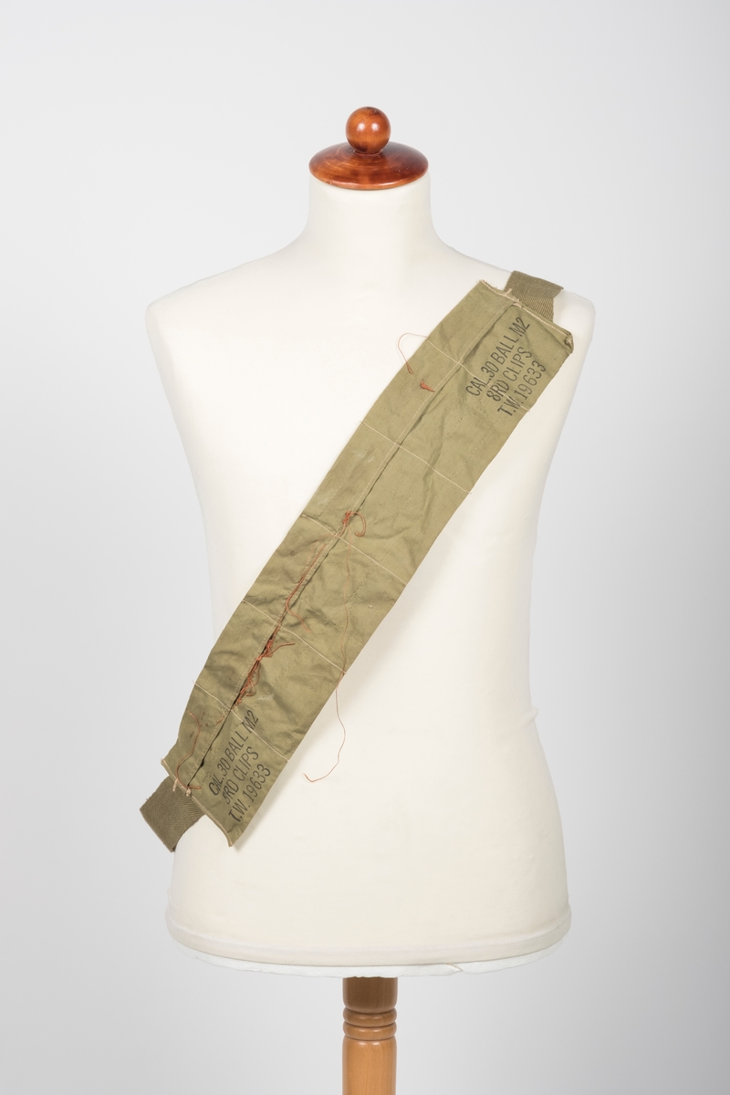 Militærgrønt ammuniasjonsbelte med seks "lommer" og påtrykk "CAL. 30 BALL M2
8RD CLIPS
T.W. 19633" på hver side. En rødbrun tråd med ukjent funksjon er sydd gjennom lommene.

Hver lomme er 8,5-9 cm bred og 10,5 cm høy.