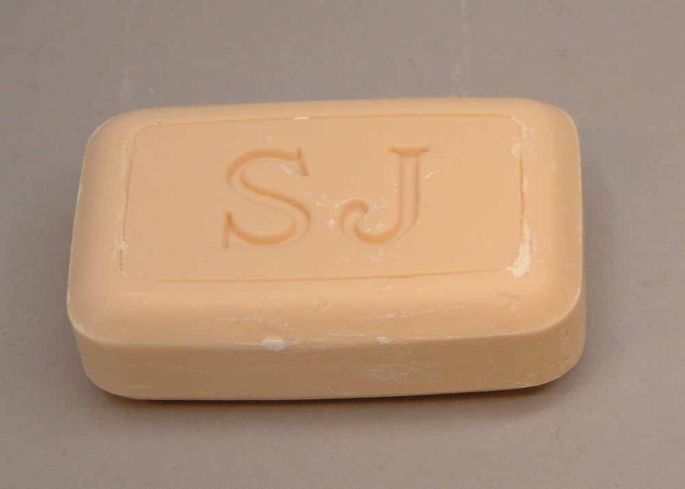 Två stycken gulvita rektangulär tvålar.
En nedsänkt rektangel ovanpå med initialerna SJ inpressade.