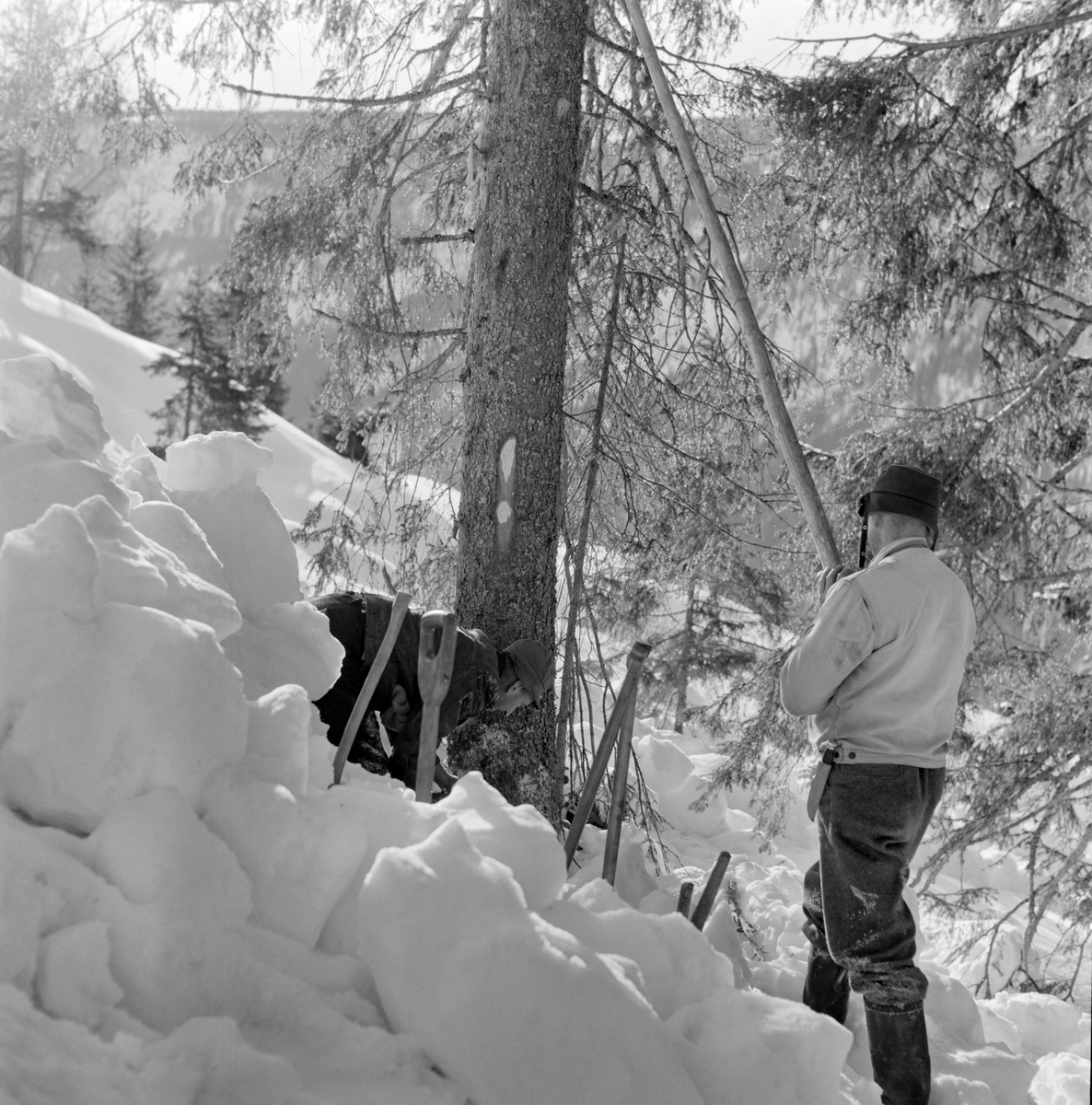 «Tømmerkjøring i Vestre Gausdal, Oppland. Kristofer Kronberget (i mørk jakke) og Ottar Gudbjørnsrud, begge fra Bødal, i arbeid»