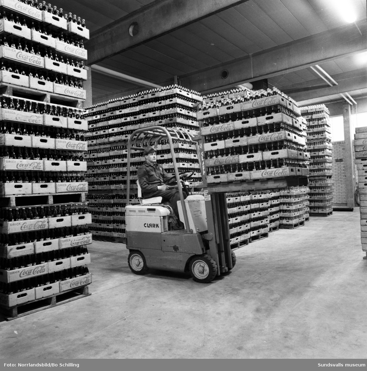 Coca-Cola-fabriken vid Bultgatan i Nacksta. Exteriörbilder samt bilder från lagret, en man kör truck bland tomma och fyllda flaskor.