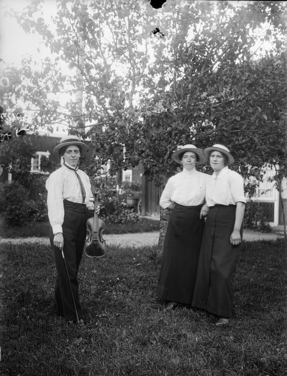 Tre damer varav en med fiol