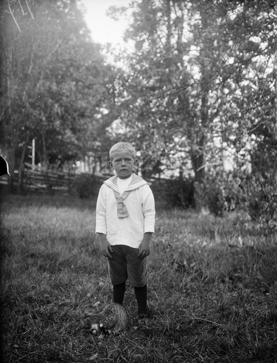 Lennart med katt i trädgård, Tibble, Torstuna socken, Uppland