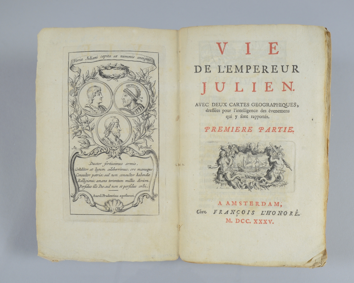 Bok, pappband, "Vie de l émpereur Julien", tryckt 1735 i Amsterdam. Del 1och 2 i samma band. Marmorerade pärmar, blekt rygg med etikett med volymens nummer. Oskuret snitt. Med utvikbara kartor. Anteckning om inköp på pärmens insida.