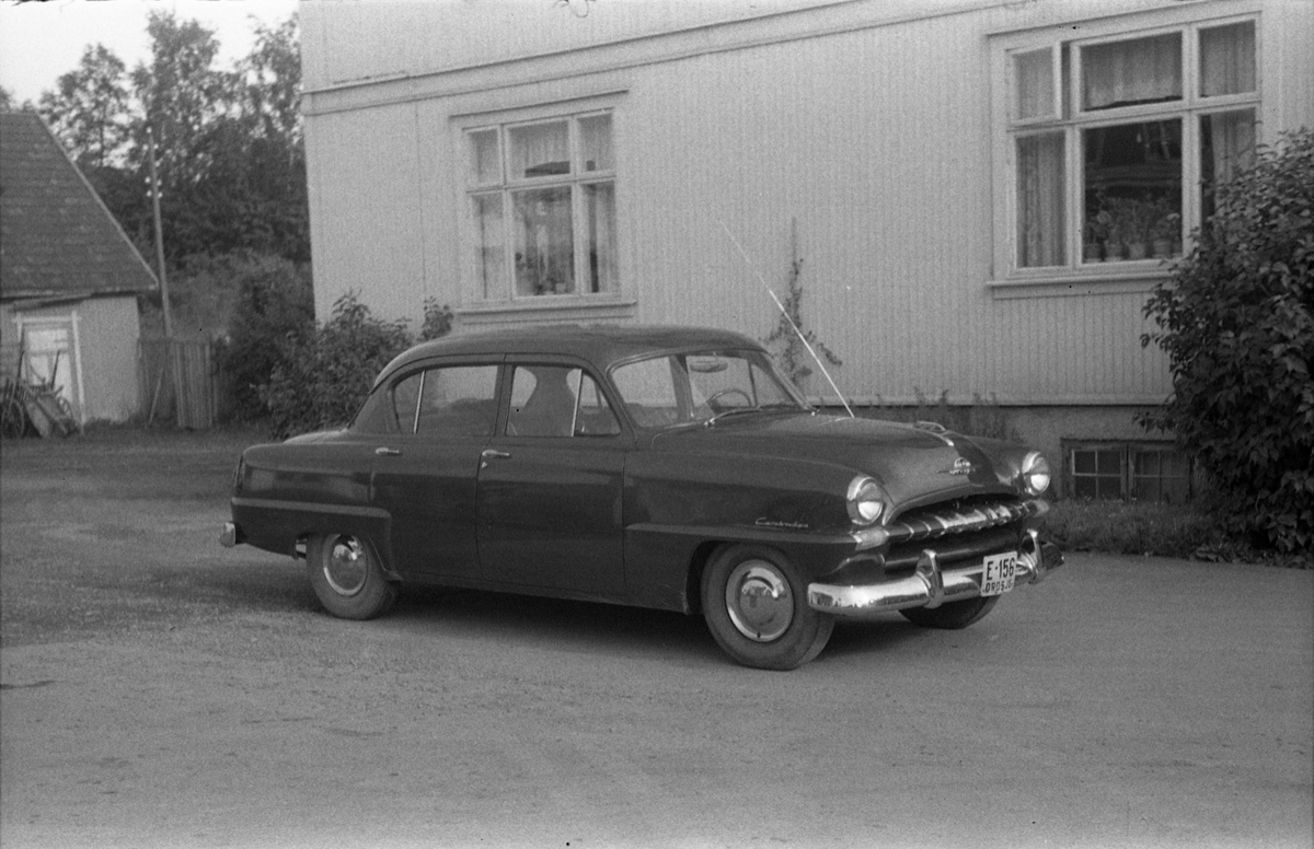 Drosje E-156 avbildet ved Grand på Lena. Bilen er iflg. informant en Plymouth Cambridge, årsmodell 1953-54.