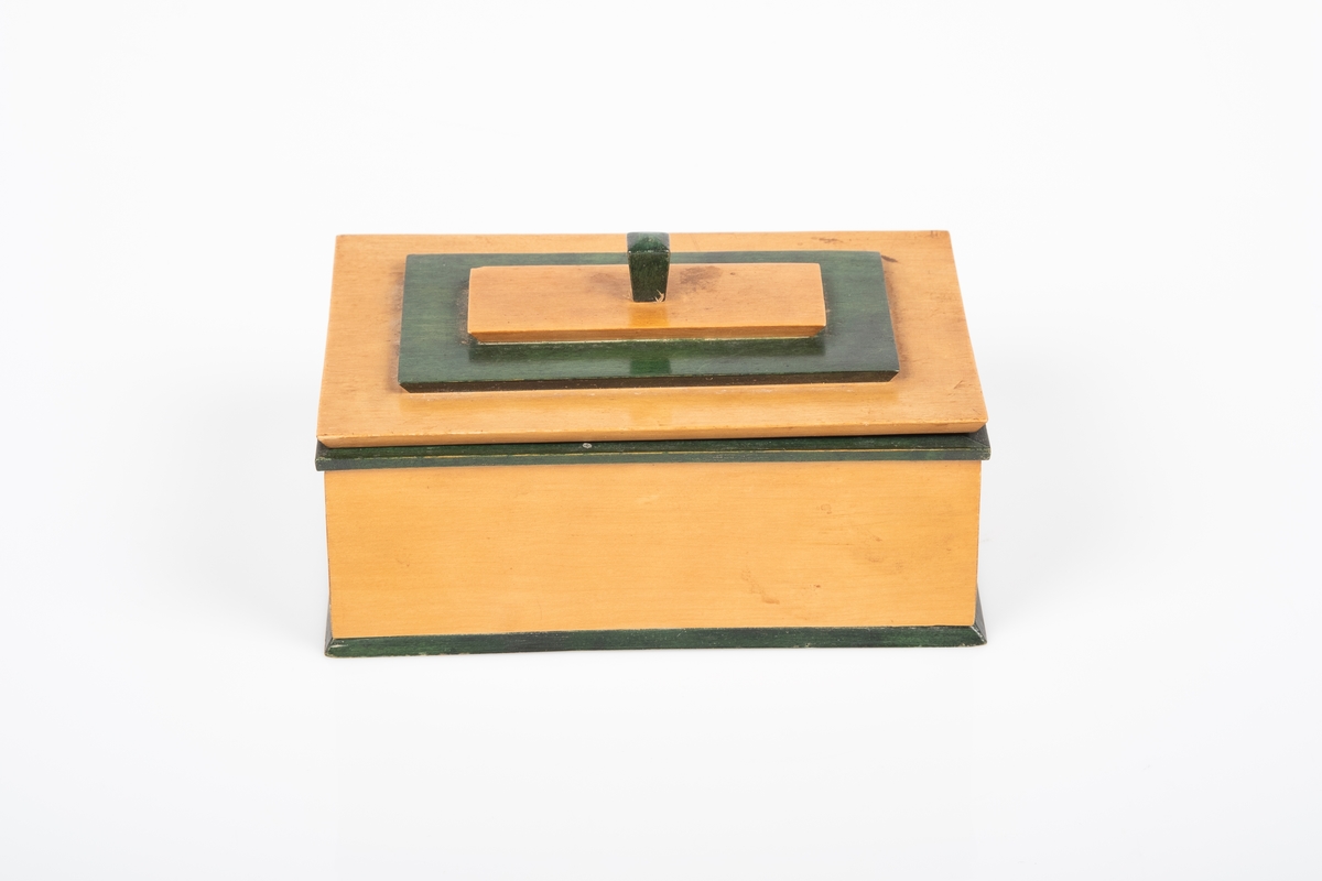 Skrinet er laget av tre. Deler av skrinet er malt grønt. Lokket er dekort med to treplater plassert oppå hverandre etter størrelse. På den øverste treplata er en knott som brukes til å åpne/lukke skrinet. Skrinet er lakkert med blank lakk.