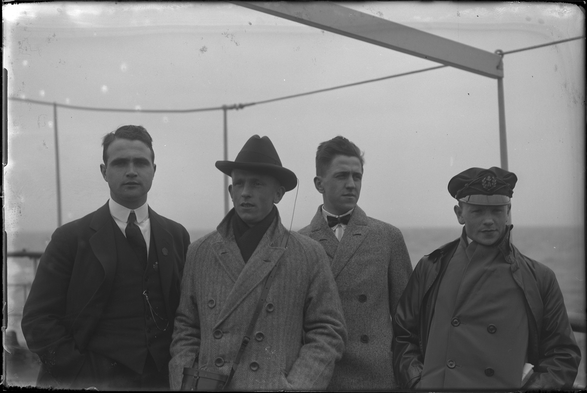 Fyra män porträtterade ute på däck på en passagerarfartyg. I fotografens egna anteckningar står: Danmarksresan, Einar, Mårten, Axelsson och Sture.