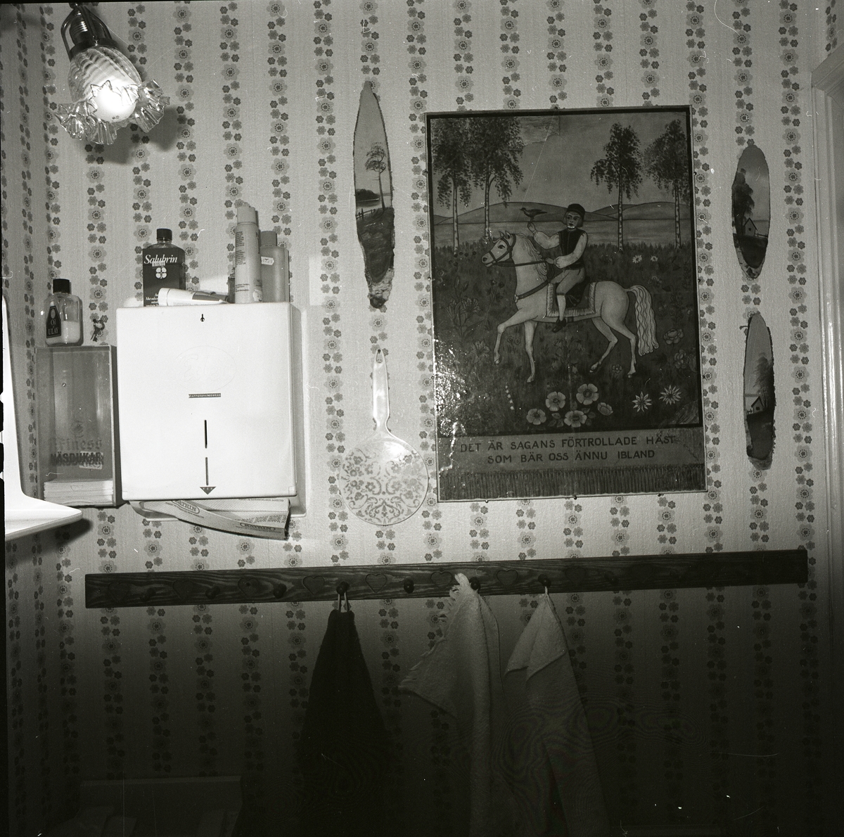 Interiör från toalettrum på nedre våningen i gården Sunnanåker, 28 april 1983. Där ser man en vägglampa, en väggbonad och en knoppbräda för handdukar.