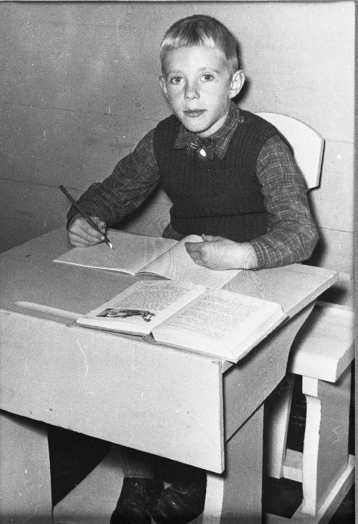 Skulebilete av Torger Åsen (30.7.1948 - ). Han gjekk på skulen på Vestly og sit her med blyant, skrivebok og lesebok. 2. klasse. (?)