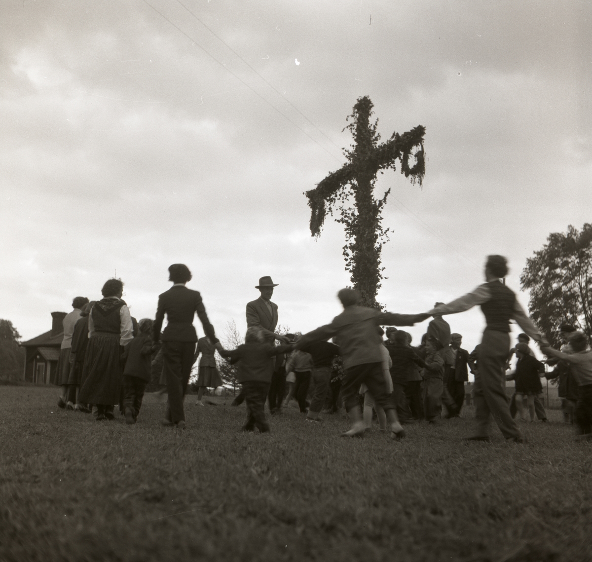 En grupp människor firar midsommar intill Trönövägskälet, 24 juni 1955 i Rengsjö.
