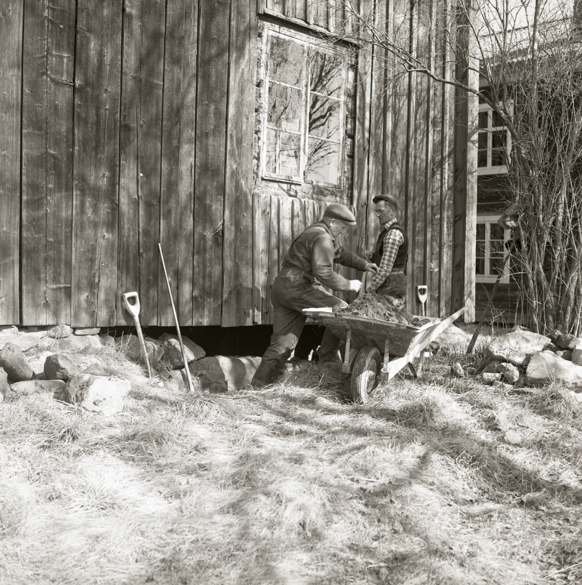 Två män justerar stenblocken i en husgrund, 1968 i Rengsjö.
