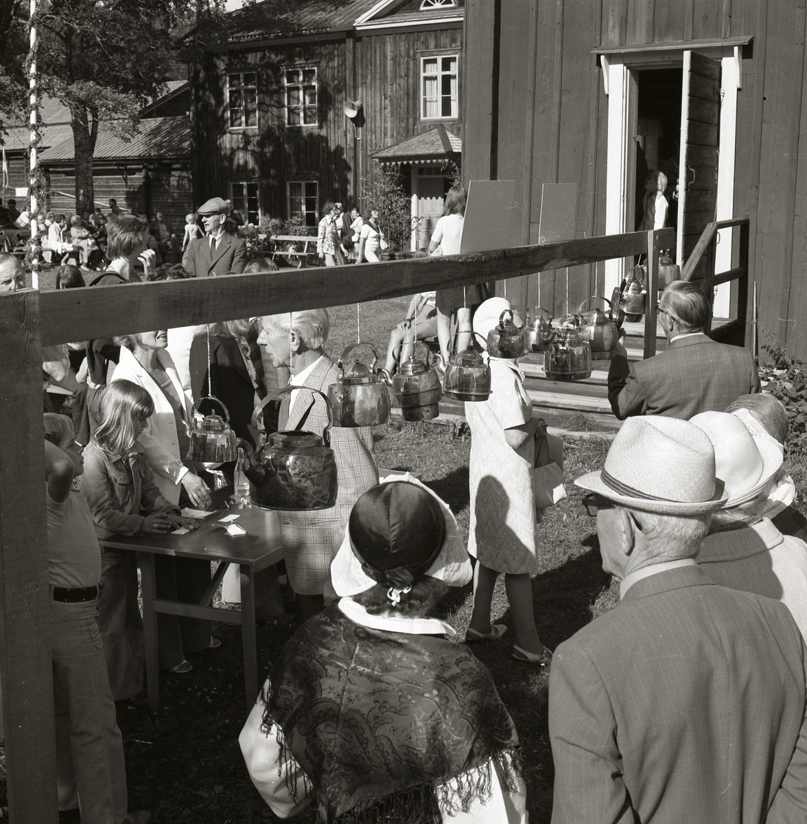 Under ett midsommarfirande vid Rengsjö hembygdsgård röstar människor i en tävling om den vackraste kopparkaffekannan, 1974.