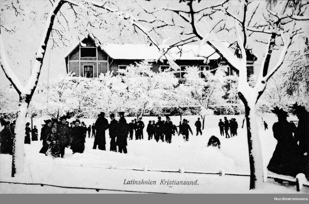 "Latinskolen Kristiansund. " Foto fra skoleplana ved Latinskolen en vinterdag, på Kirkelandet i Kristiansund. Fra Nordmøre museums fotosamlinger.