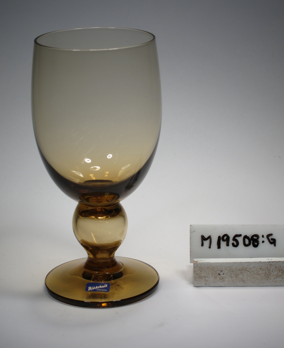Ölglas tillhörande servis "Desirée".
Äggformad kupa, ben med kula, skivfot.
Rökgulbrunt klarglas.
Ovan angivna mått avser maxdiameter.
Inskrivet i huvudkatalogen 1968.
Funktion: Ölglas