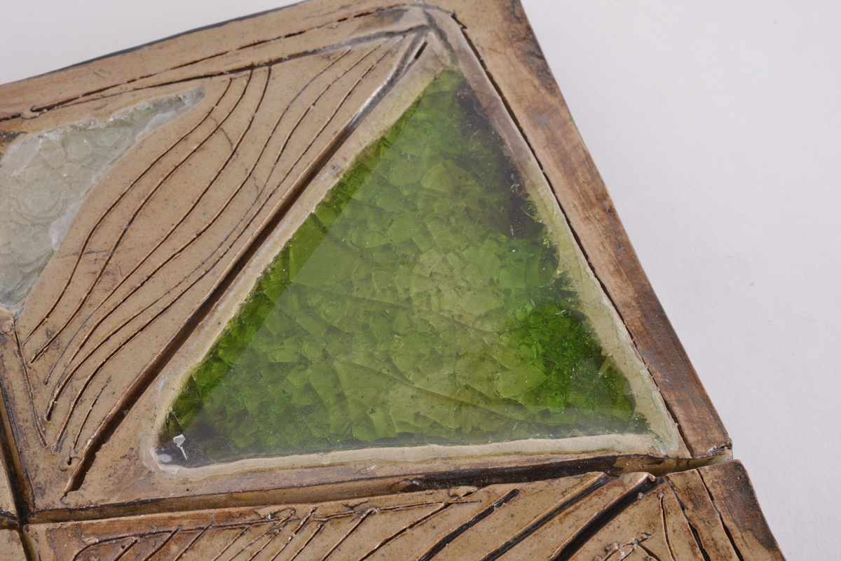 Rektangulært bilde laget av brent leire og glass. Bildet er montert på en treplate.