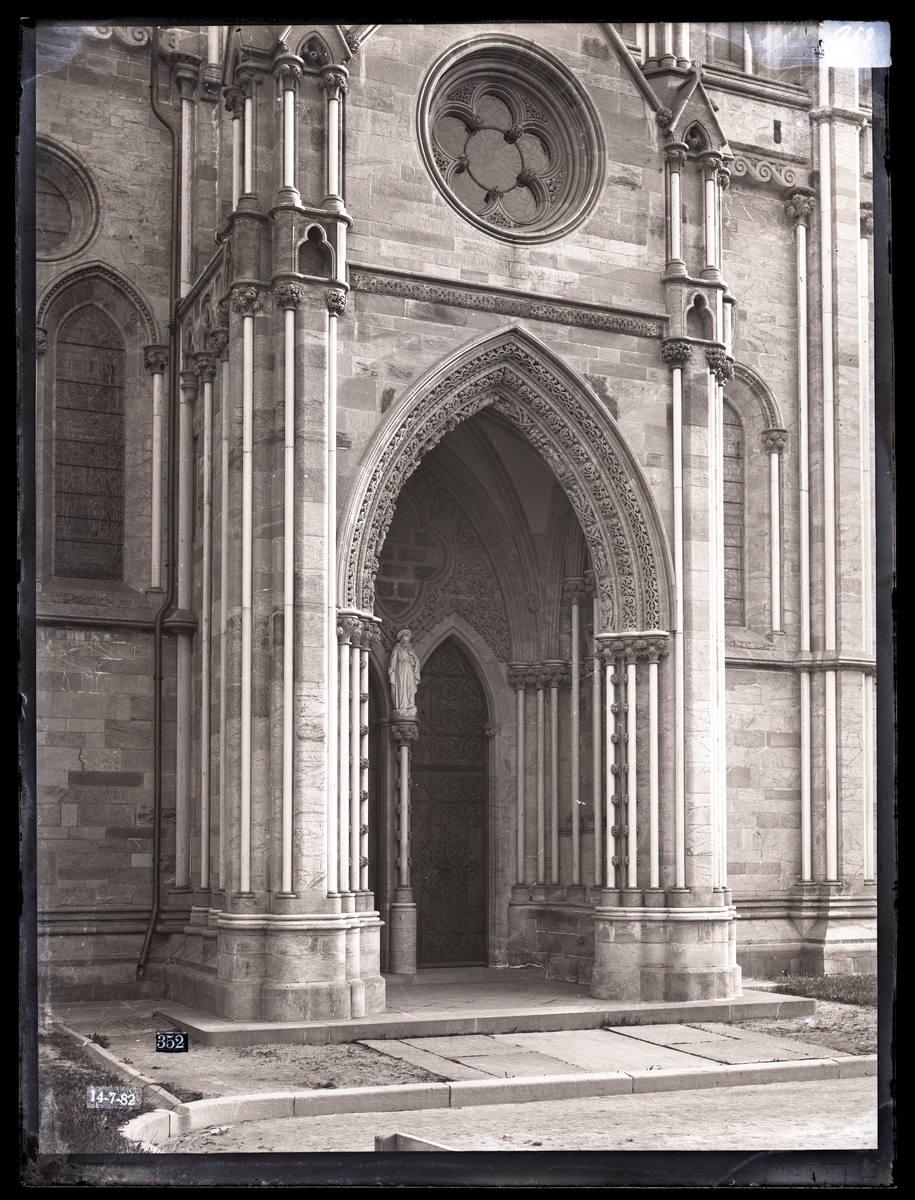 Kongeinngangen på søndre side av koret i Nidarosdomen. Her etter restaurering. Marmorskulptur med Kristus inne i portalen (skulptur laget av Paul Bøe i 1882). Bue med gotiske ornament og skulpturer. Nytt glassmaleri over portalen.