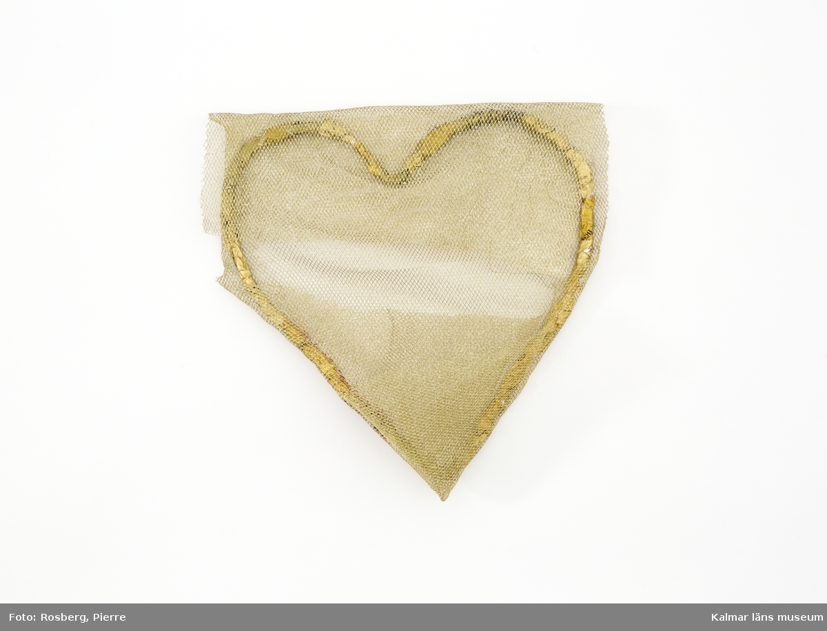 Konstverket har titeln Hjärta av guld. Ram med form av ett hjärta med guldfärgat nät fastsytt.