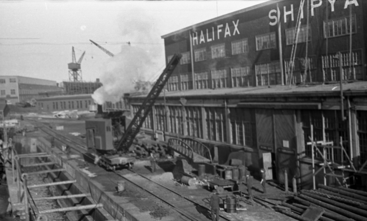 Tørrdokken i Halifax fylles. Skipsverftet med kraner og arbeidere til høyre og i bakgrunnen. Suderøy gjøres klar til avgang.