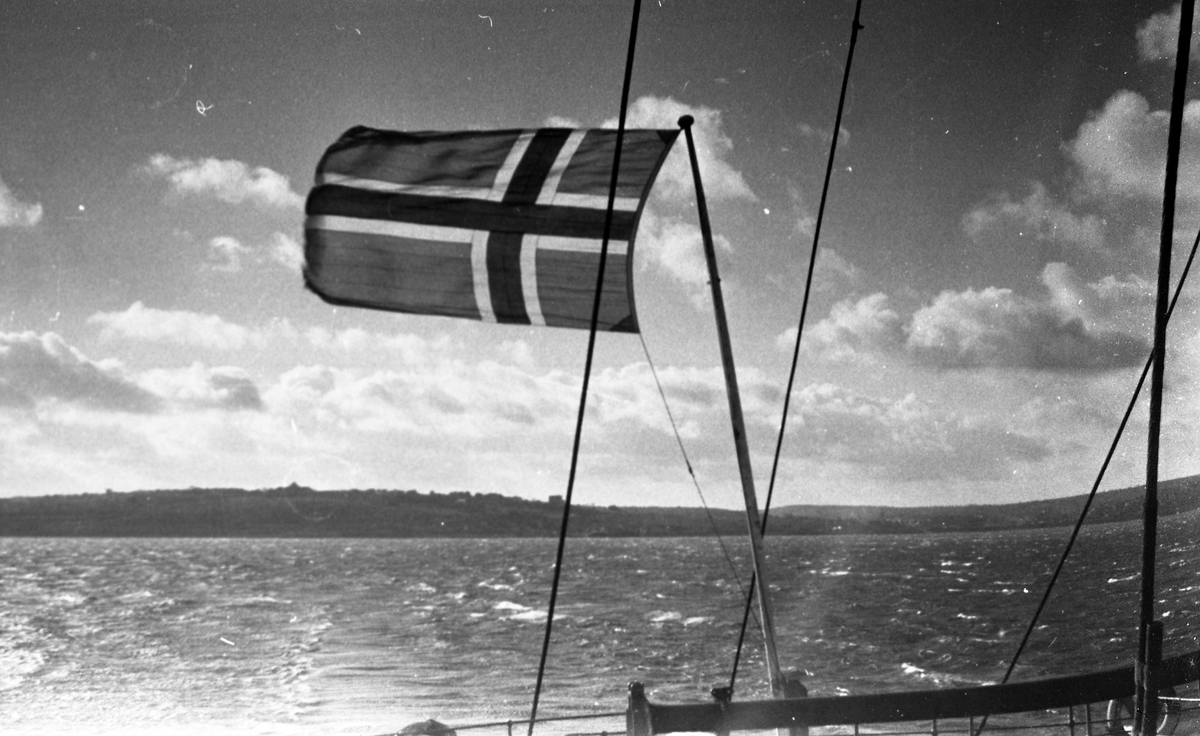Det Norske flagget vaier i vinden. Suderøy på vei til fangstfeltet.
