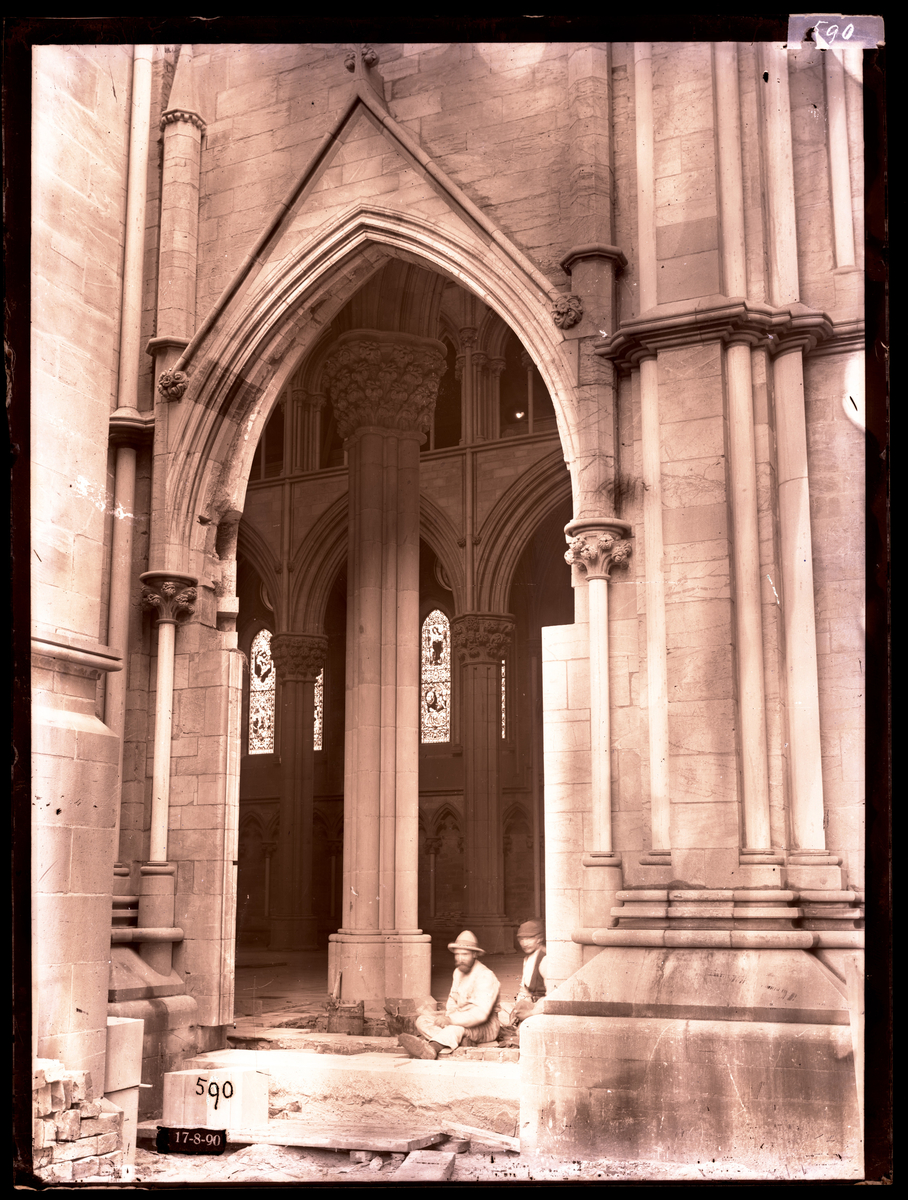 Nordportalen i koret (Davidsportalen) i Nidarosdomen under restaurering. To restaureringsarbeidere sitter inne i portalen, og arbeider med legging av marmorfliser.