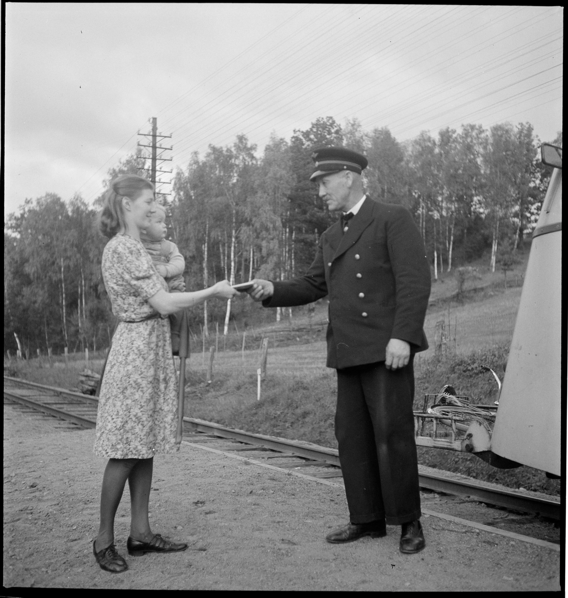 Järnvägstjänsteman i samspråk med kvinna.