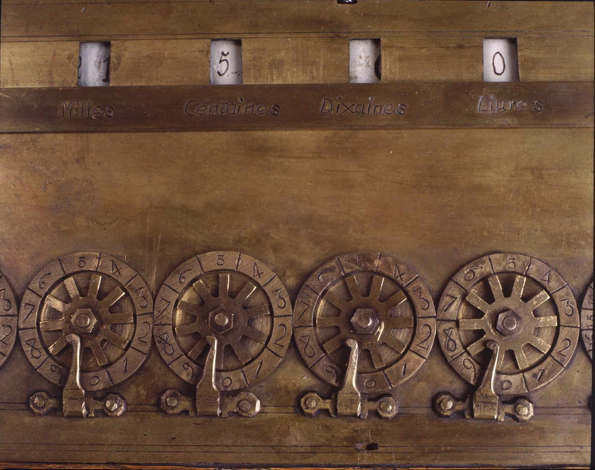 Replik av de första räknemaskiner som konstruerades av Blaise Pascal, för addition och subtraktion. 1640-talet. Härtill hör fyra lösa ben av trä TM21265:b. Med åtta hjul för maximalt 999999 livres, 19 sols och 11 deniers.