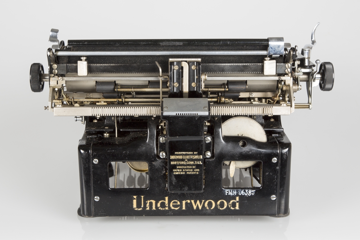 Rektangulær mekanisk Amerikansk-produsert skrivemaskin fra ca. 1900. Høy og tung modell. Står på fire gummierte føtter.