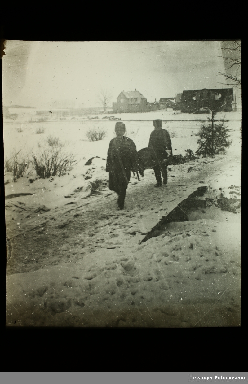 To  russiske menn, trolig soldater, bærer en sykebåre under 1.verdenskrig.