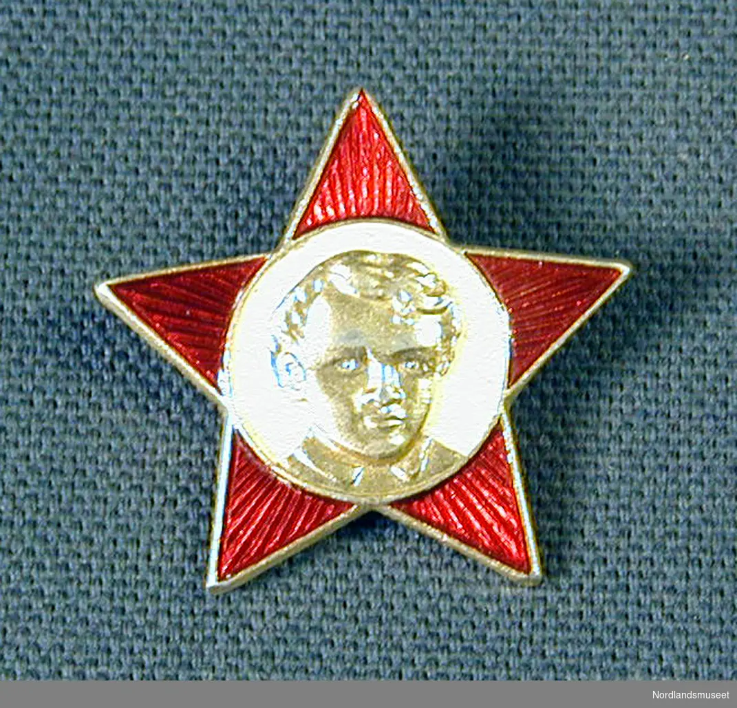 en femtakket rubinrød stjerne med et portret av Lenin som barn