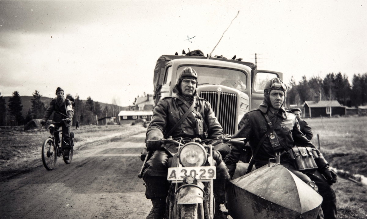 Portrettfotografi av trafikkmenn og mc- ordonnanser i Sverige under 2. verdenskrig. To menn kjører motorsykkel med sidevogn.