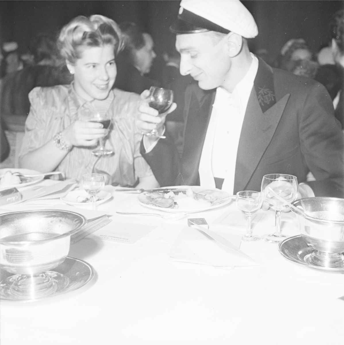 Man och kvinna vid dukat festbord, sannolikt på rikssalsbanketten i samband med Östgöta nations 300-årsjubileum, Uppsala 1946