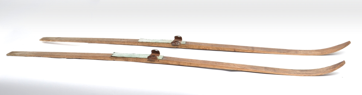 Ski, treski med binding "Gresshoppa" regulerbar, patentert av L'Abee Lund, med footplat av lys grønn linoleum. Ingen spor etter strammer eller bånd.