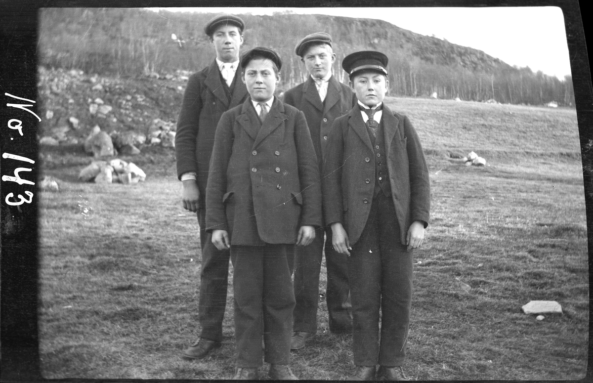 Gruppeportrett av fire unge menn stående utendørs på Bjørnå på Grytøy.