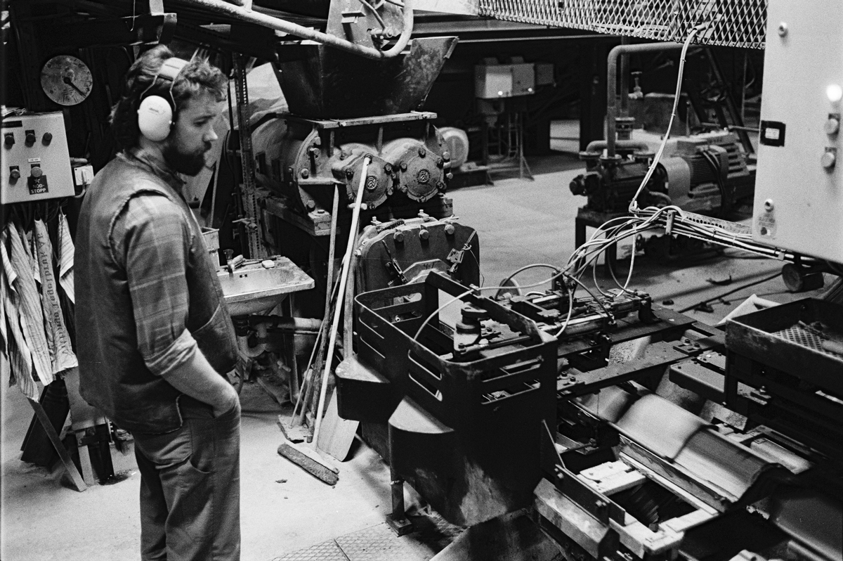Sättare Tommy Hellbom övervakar tillverkningen av enkupigt taktegel i maskinhallen, Vittinge Tegelbruks AB, Vittinge socken, Uppland 1986