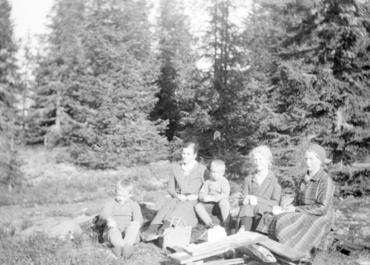 Voksne og barn tar en rast ved Balbergskampen. Personene er oppgitt å være: Fra venstre Arne, Helene, Simen (?), Sigrid og Aaslaug Jørstad.