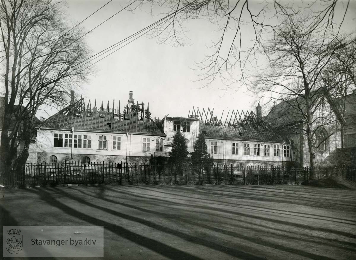Kongsgård skole etter brannen 5. april 1942. Skolegården og rektorhagen. Brannen oppstod mens tyskerne hadde sitt stabskontor på Kongsgård. Det var etter et nachspiel at en guirlander av papir og nips tok fyr.