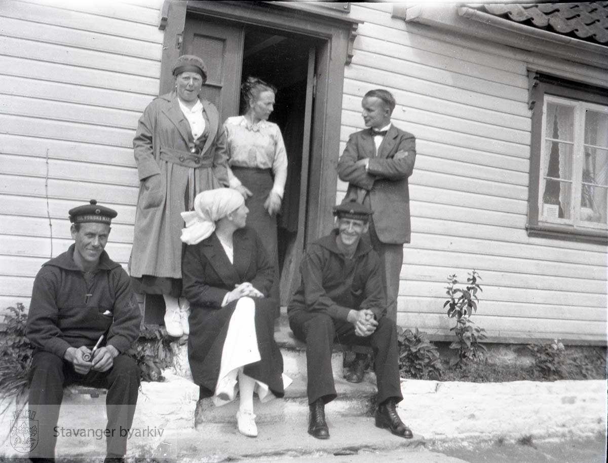 To matroser, tre kvinner og en mann i døråpningen til Anna Jakobsen Pensjonat