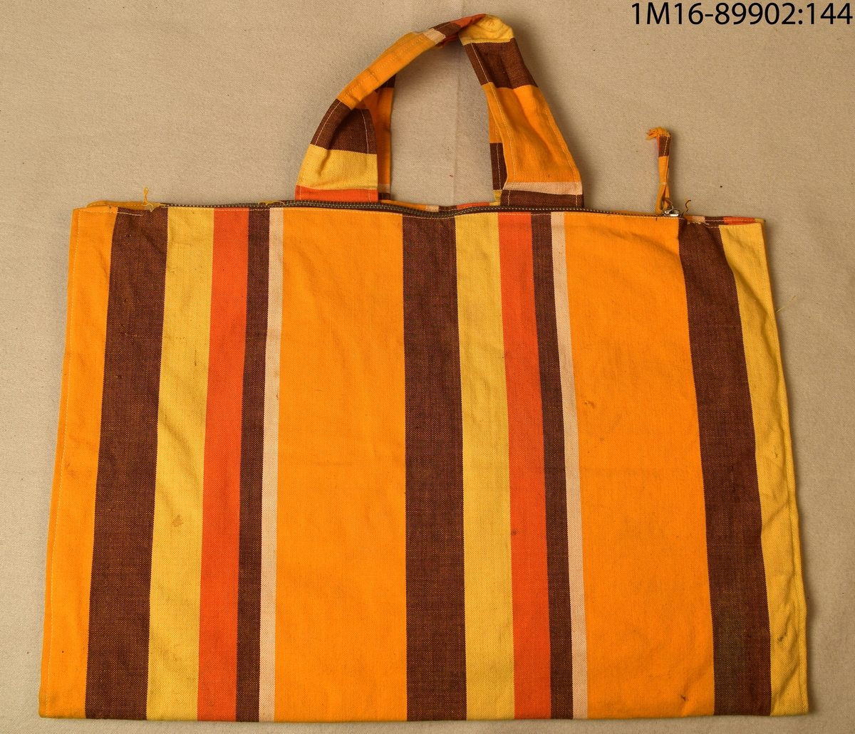 Badväska i randvävt tyg i gul, orange, brun och vit. Har dragkedjor i metall.