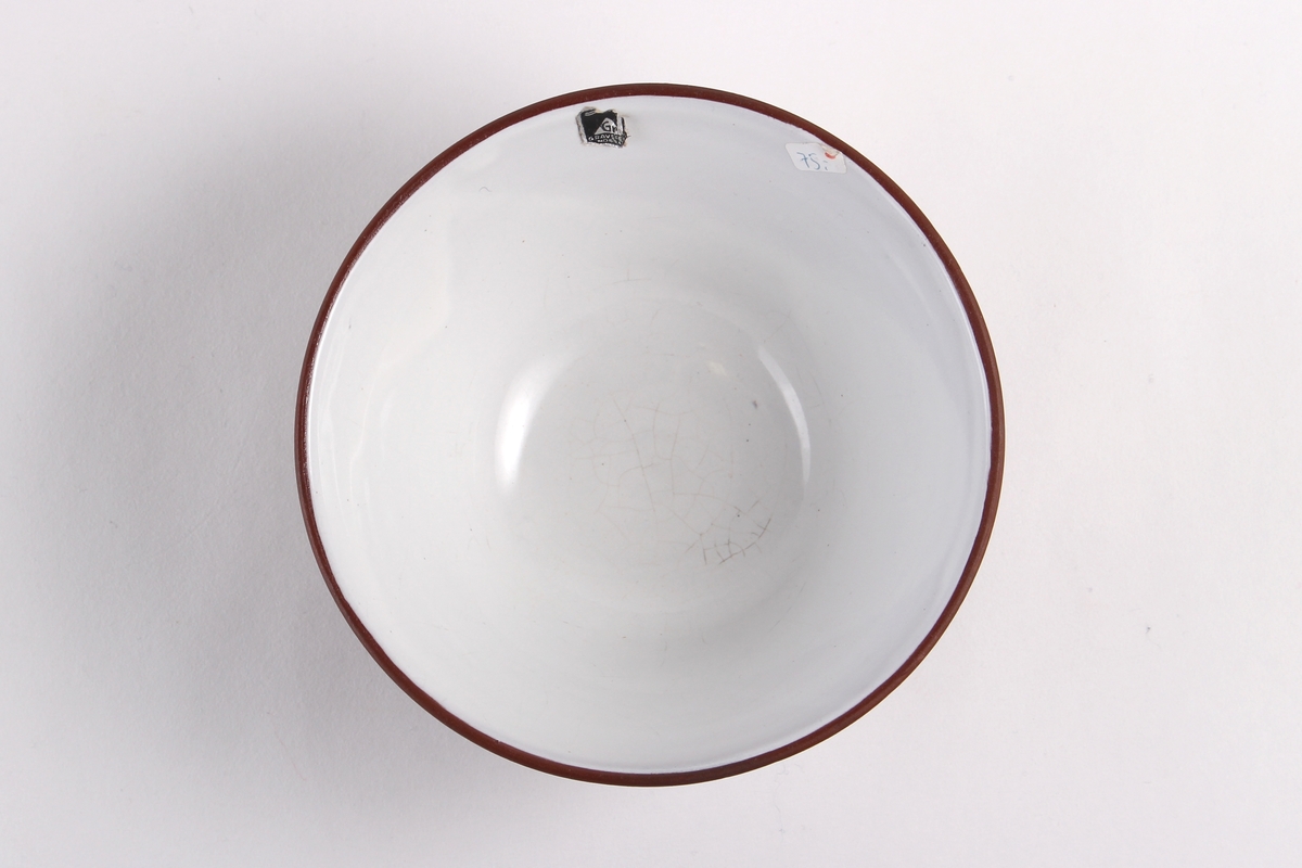 Skål som innvendig er glasert hvit og utvendig uglasert med påmalt mønster i hvitt.